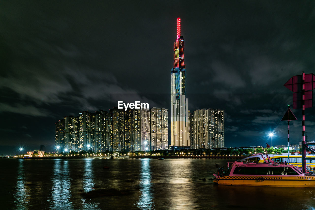 ILLUMINATED BUILDINGS BY CITY AT NIGHT