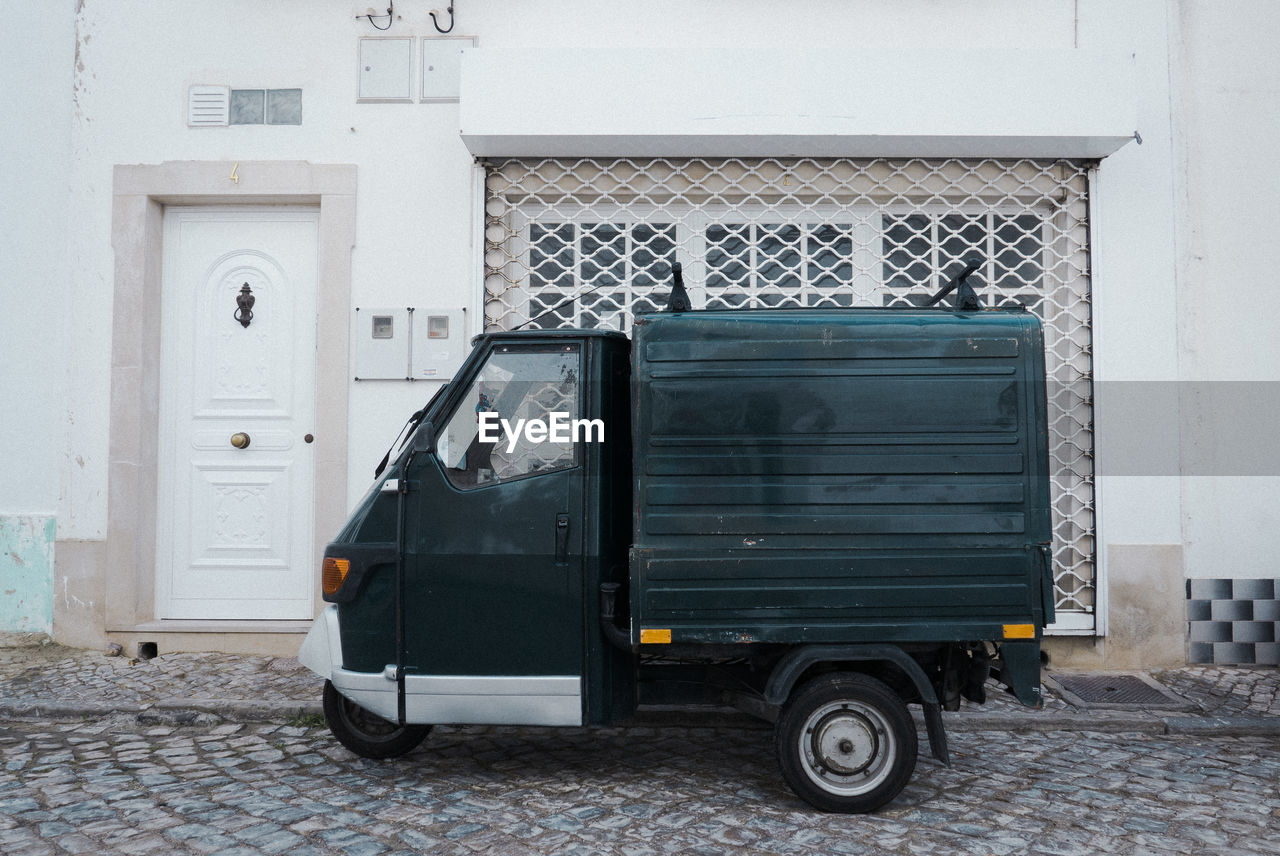 CAR PARKED ON STREET OUTSIDE HOUSE