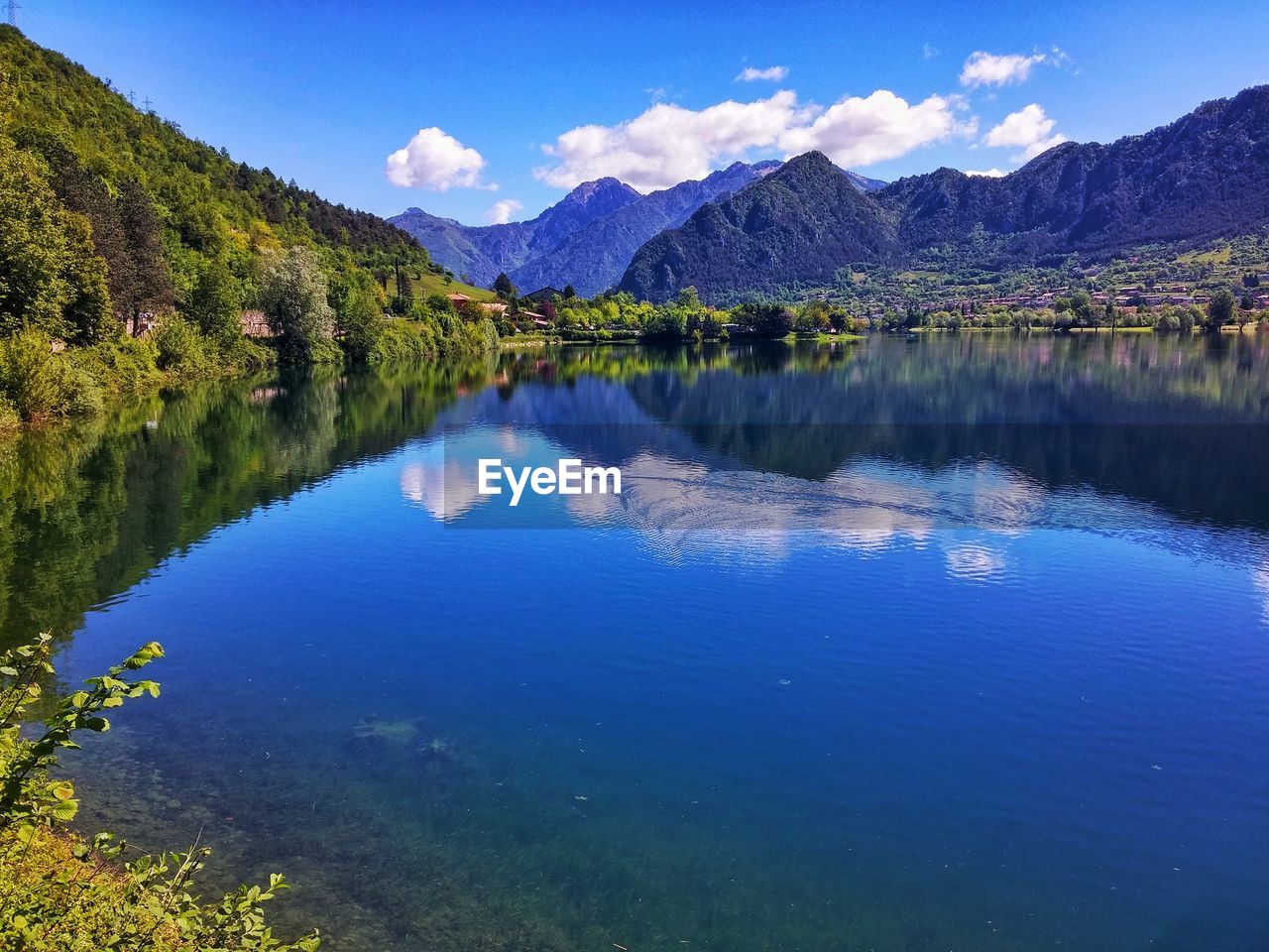 Scenic view of lake and mountains against blue sky