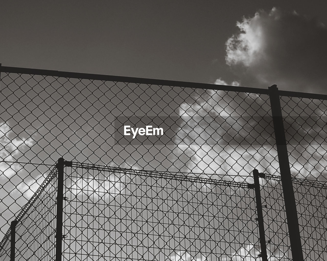 LOW ANGLE VIEW OF FENCE AGAINST SKY SEEN THROUGH CHAINLINK