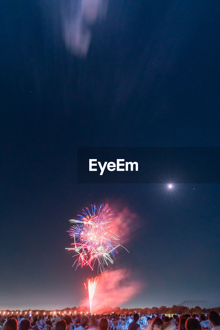 LOW ANGLE VIEW OF FIREWORKS IN SKY AT NIGHT