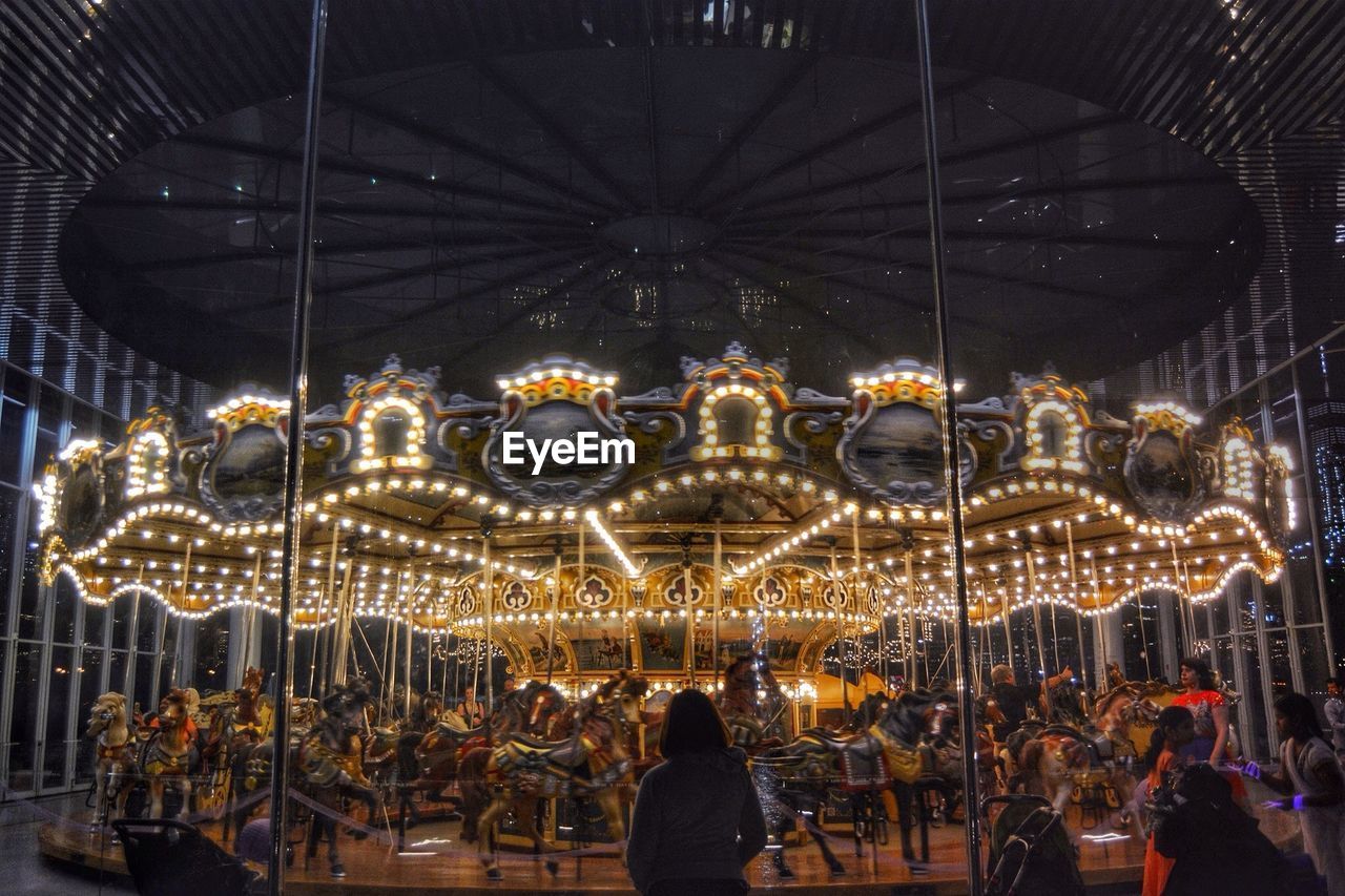 View of people looking at carousel in motion