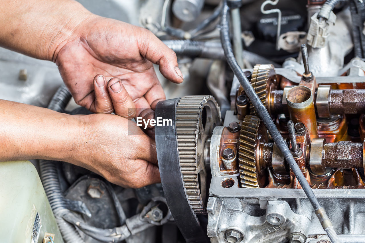 Cropped hand of man working at machine