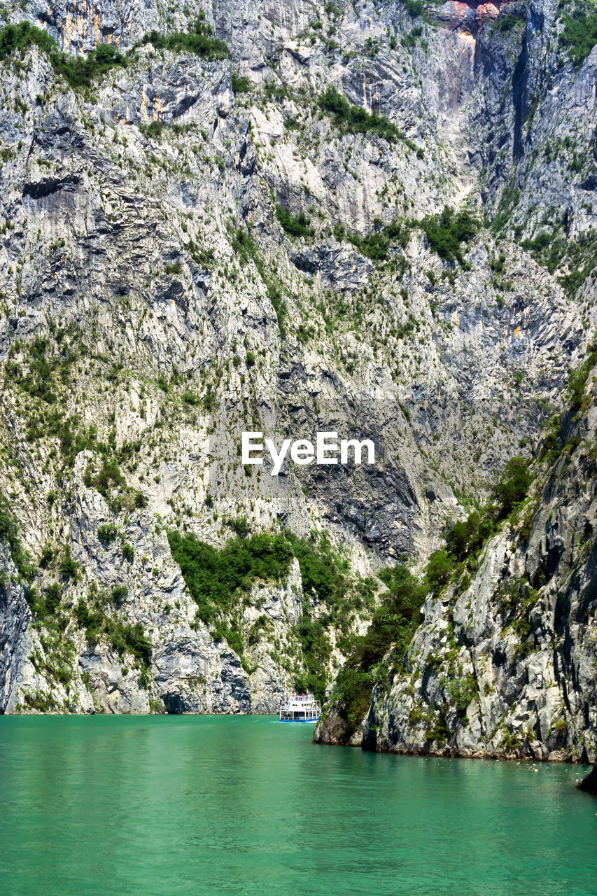 SCENIC VIEW OF SEA AGAINST MOUNTAIN