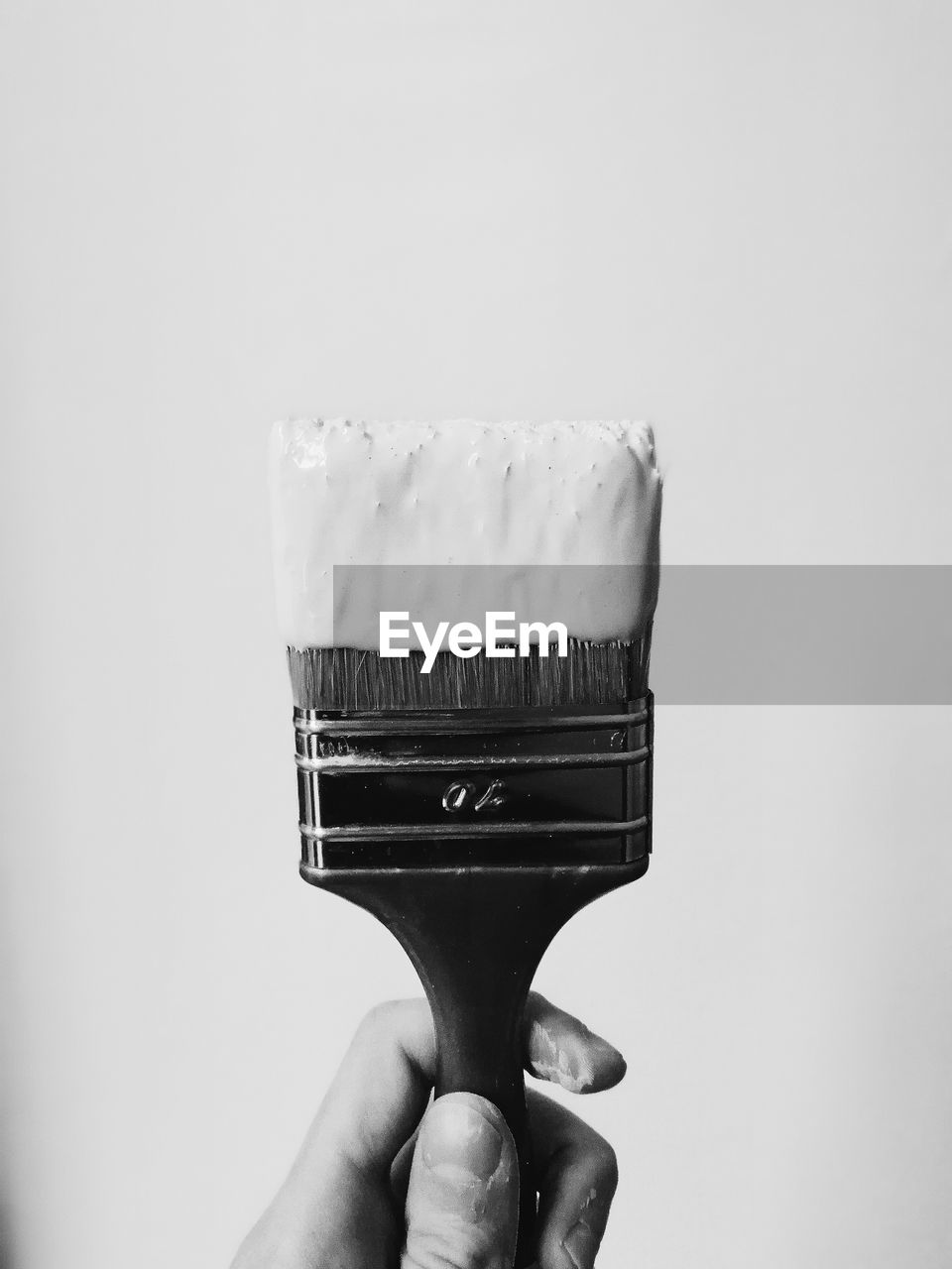 Cropped hand holding brush against white background