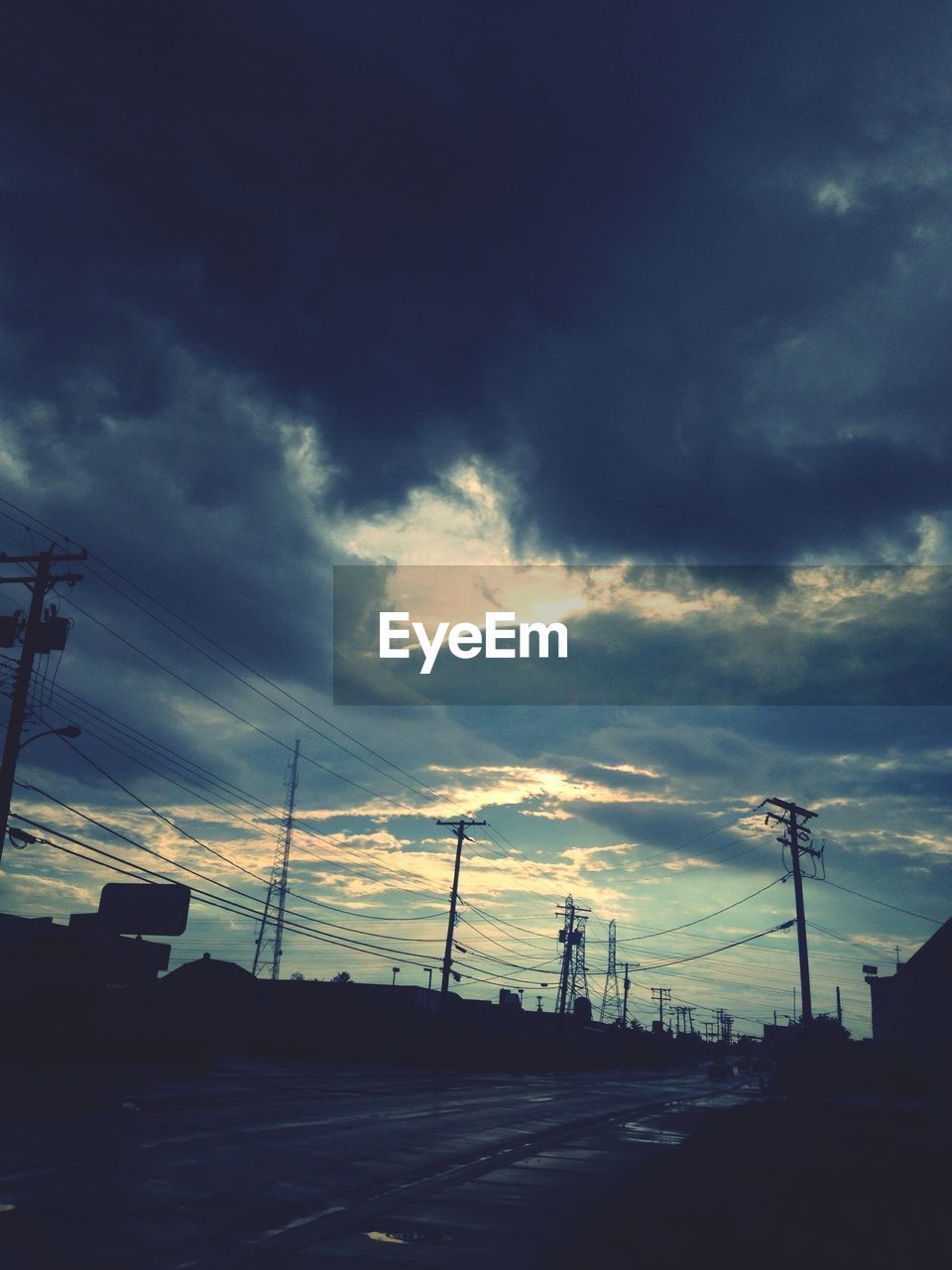 LOW ANGLE VIEW OF POWER LINES AGAINST CLOUDY SKY