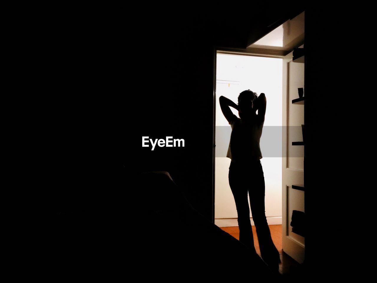 Silhouette woman standing at doorway