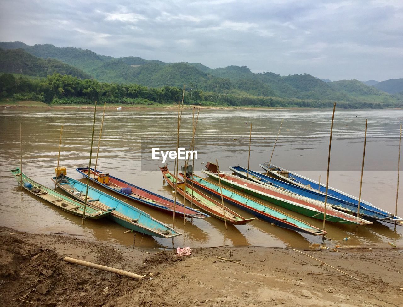 SCENIC VIEW OF BOATS MOORED IN LAKE AGAINST SKY