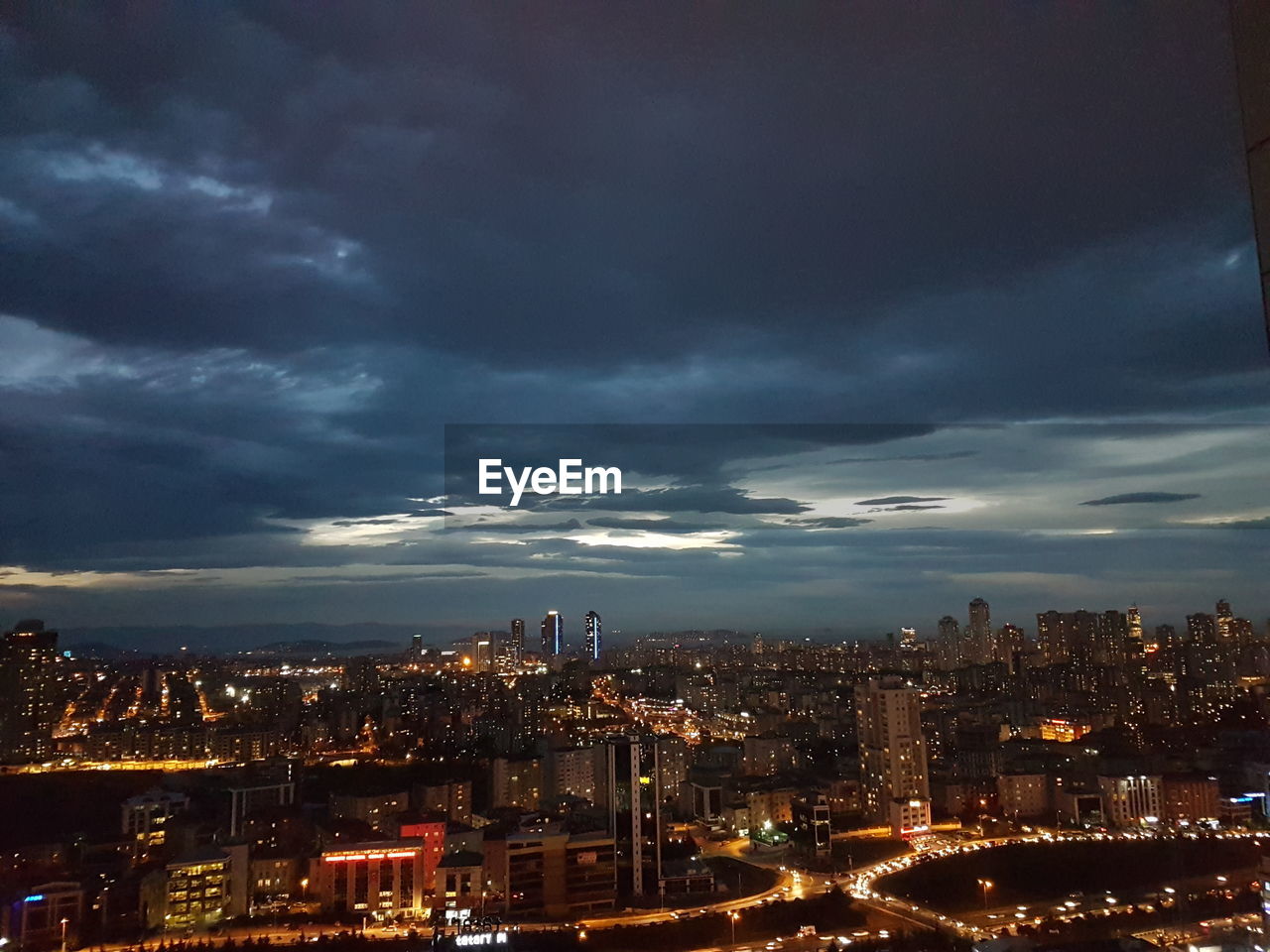 Illuminated cityscape against sky at night