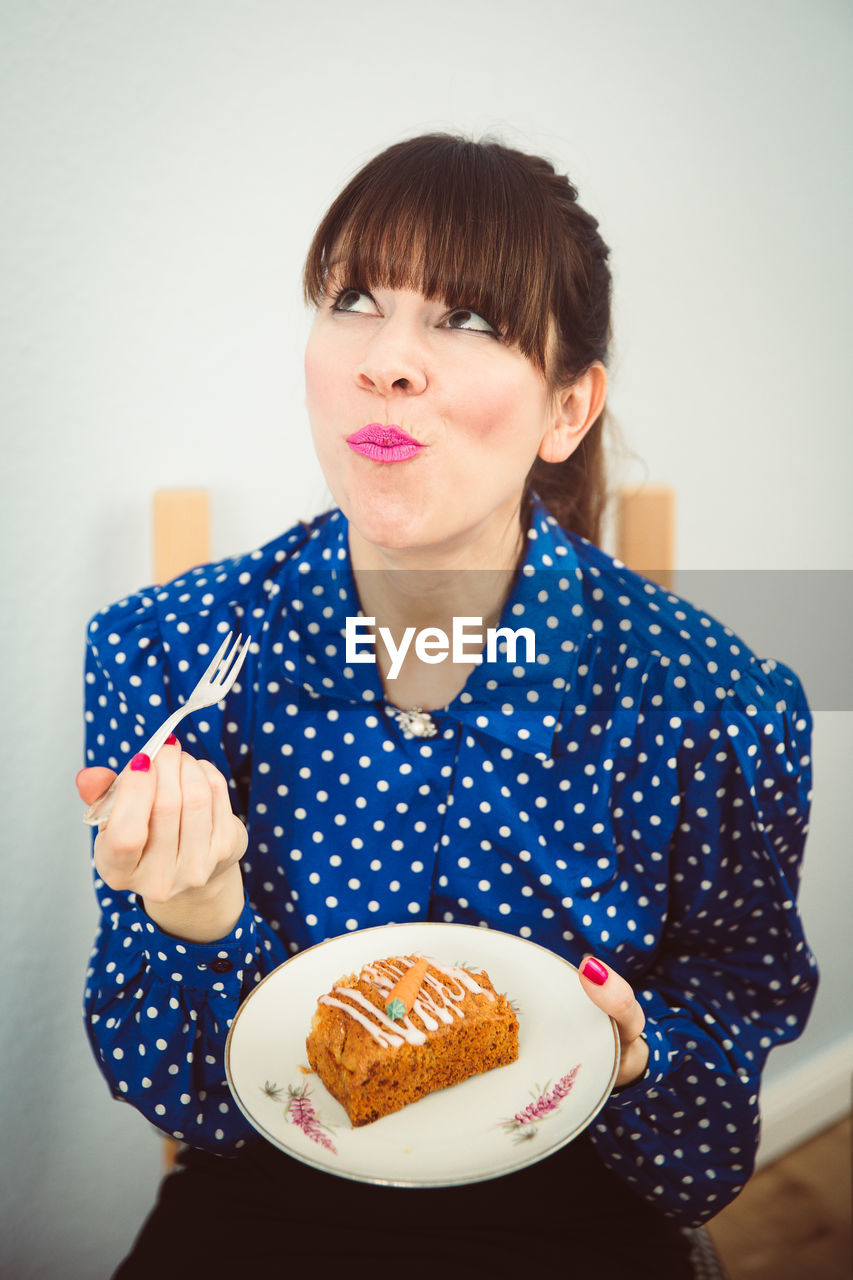 Mid adult woman eating sweet food at home