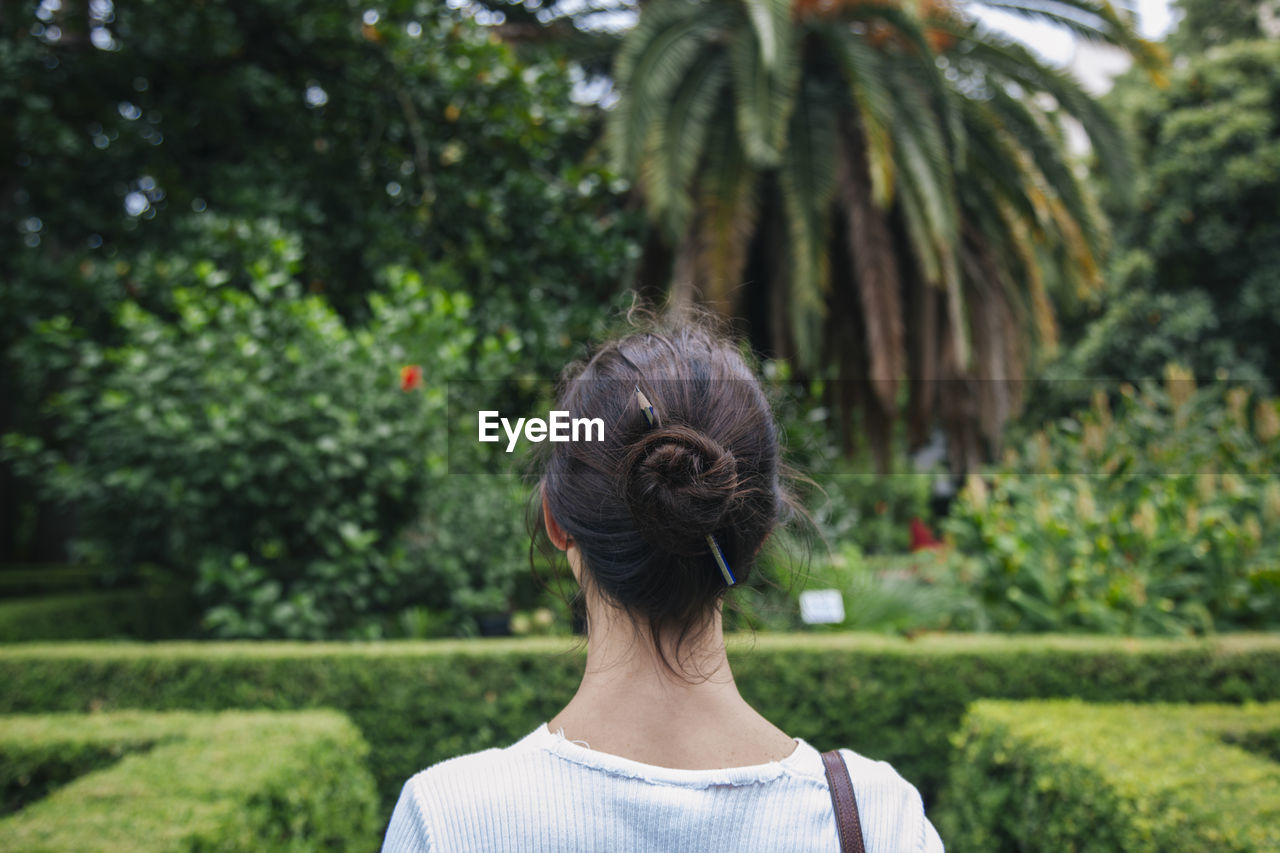 Rear view of woman against trees