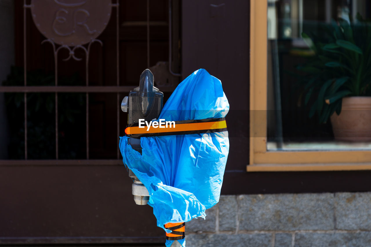 Rear view of man with umbrella on street against building