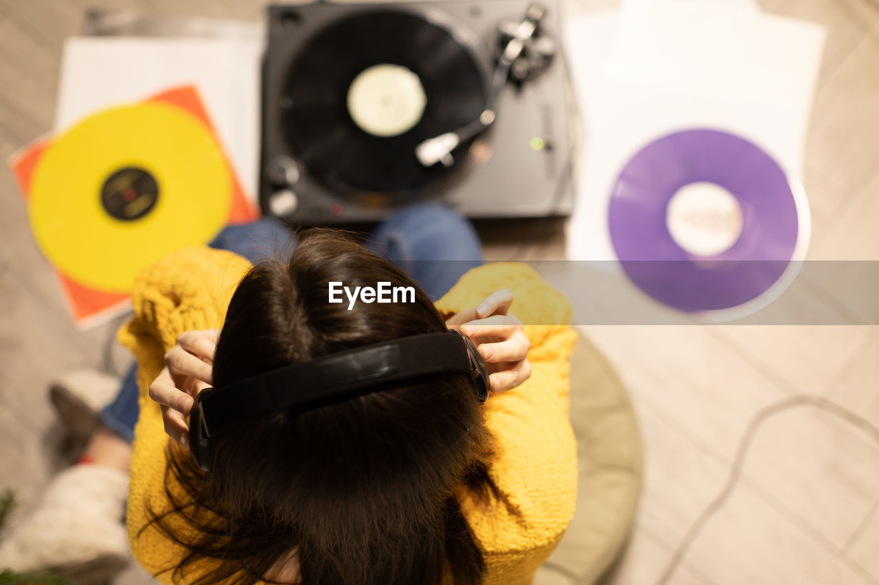 High angle view of woman listening music at home