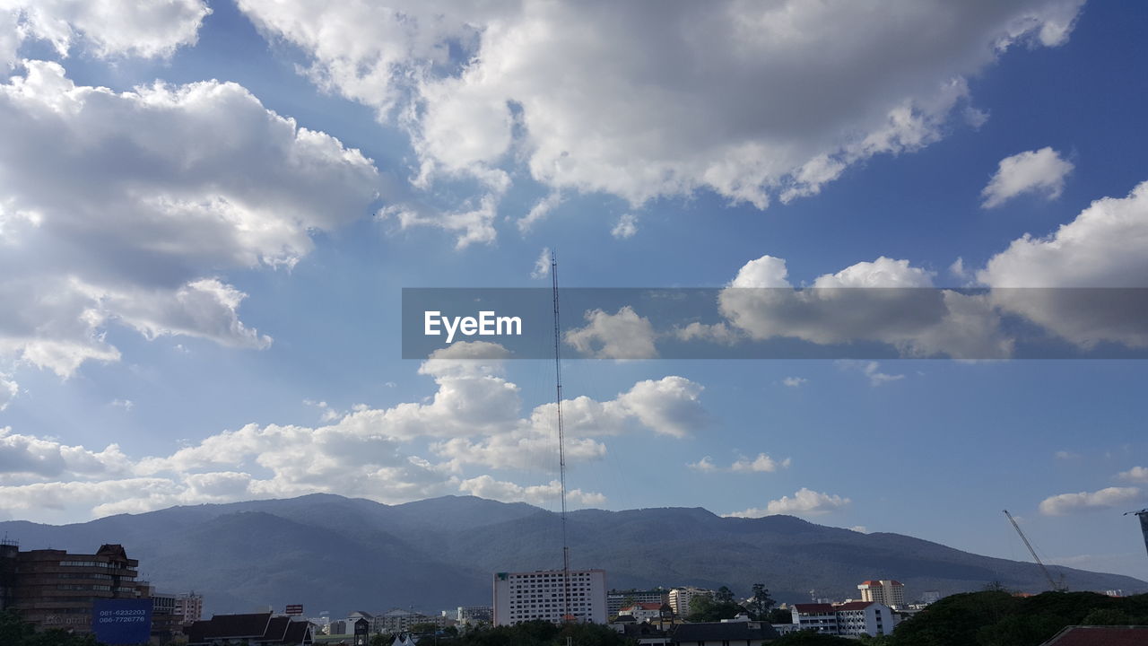 View of cityscape against cloudy sky