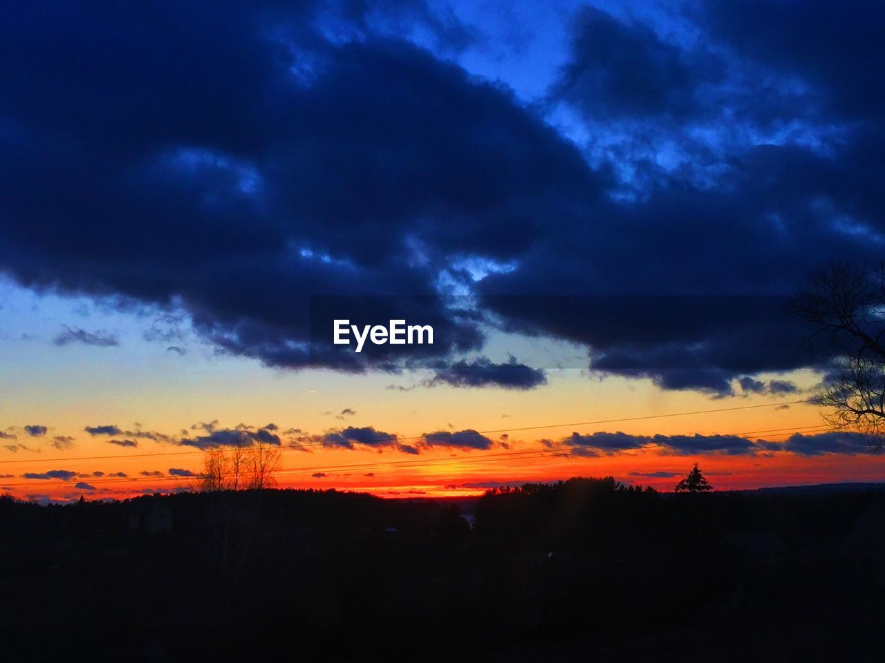 SILHOUETTE LANDSCAPE AGAINST DRAMATIC SKY DURING SUNSET