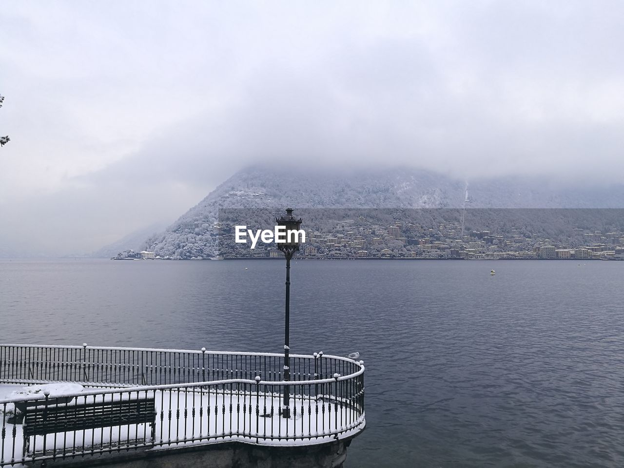 Scenic view of como lake against sky during winter