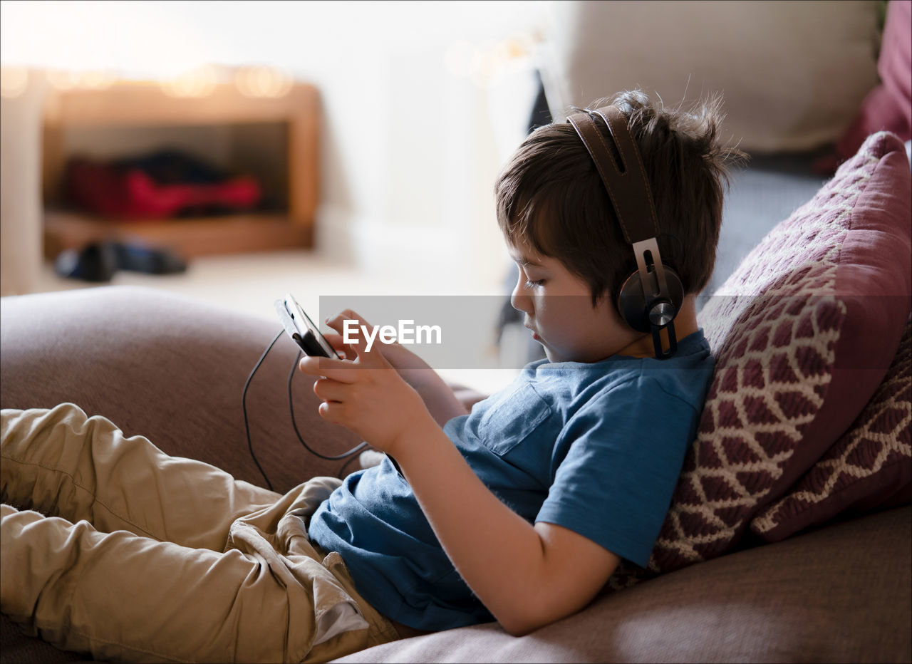 Side view of boy using digital tablet