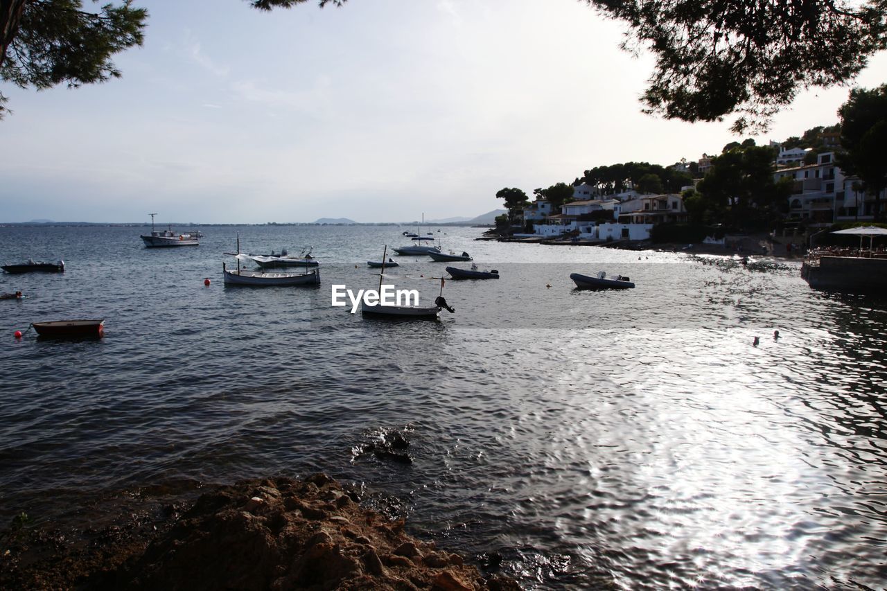 Boats moored in sea against sky