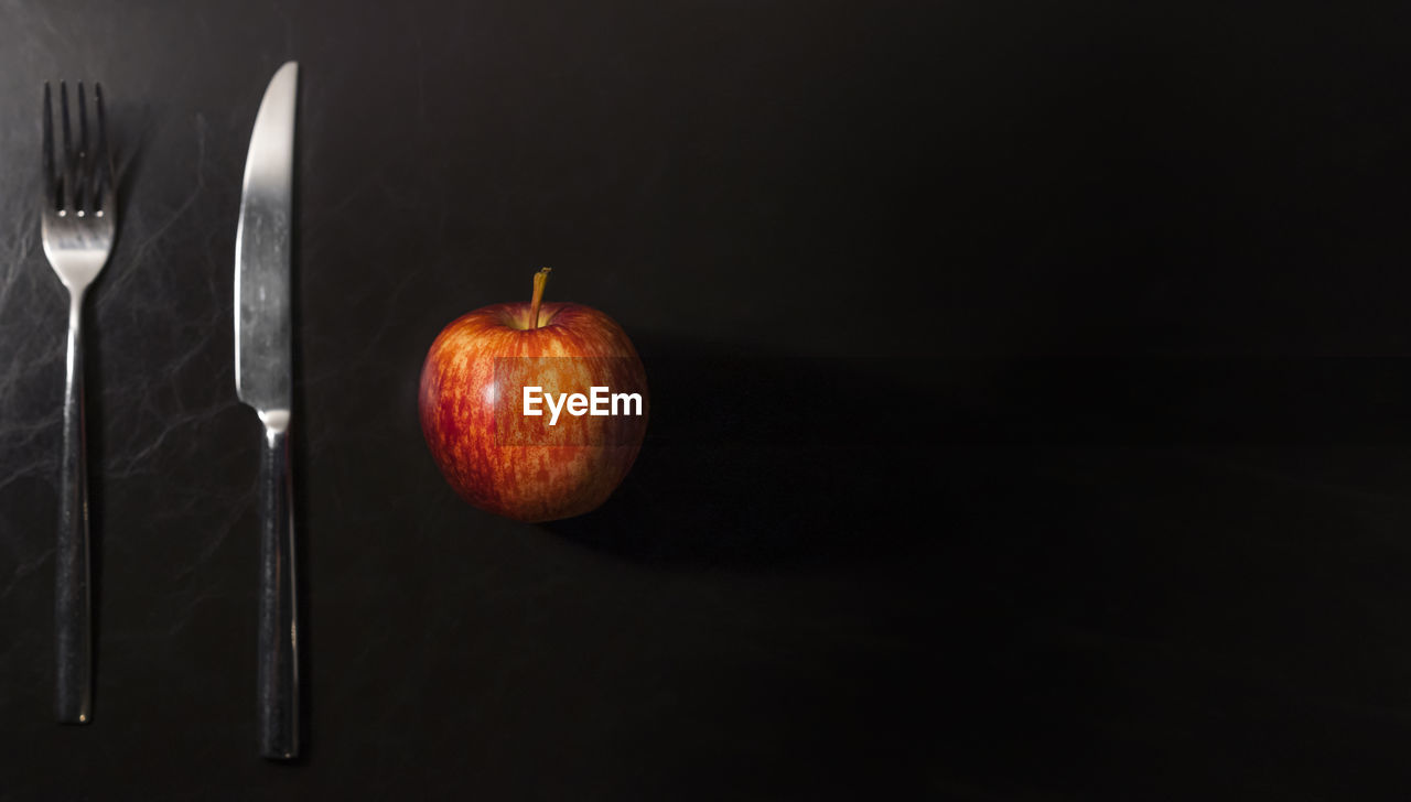 Close-up of apple on table against black background