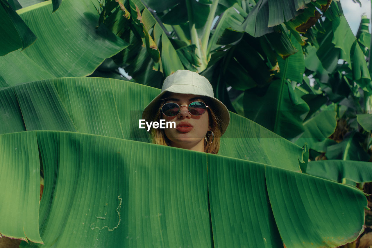 Portrait of woman in sunglasses amidst plants