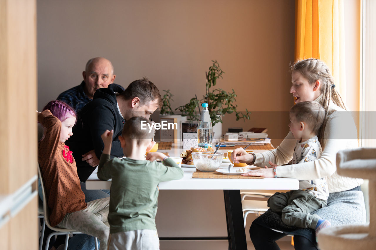 Multi generation family eating meal around kitchen table