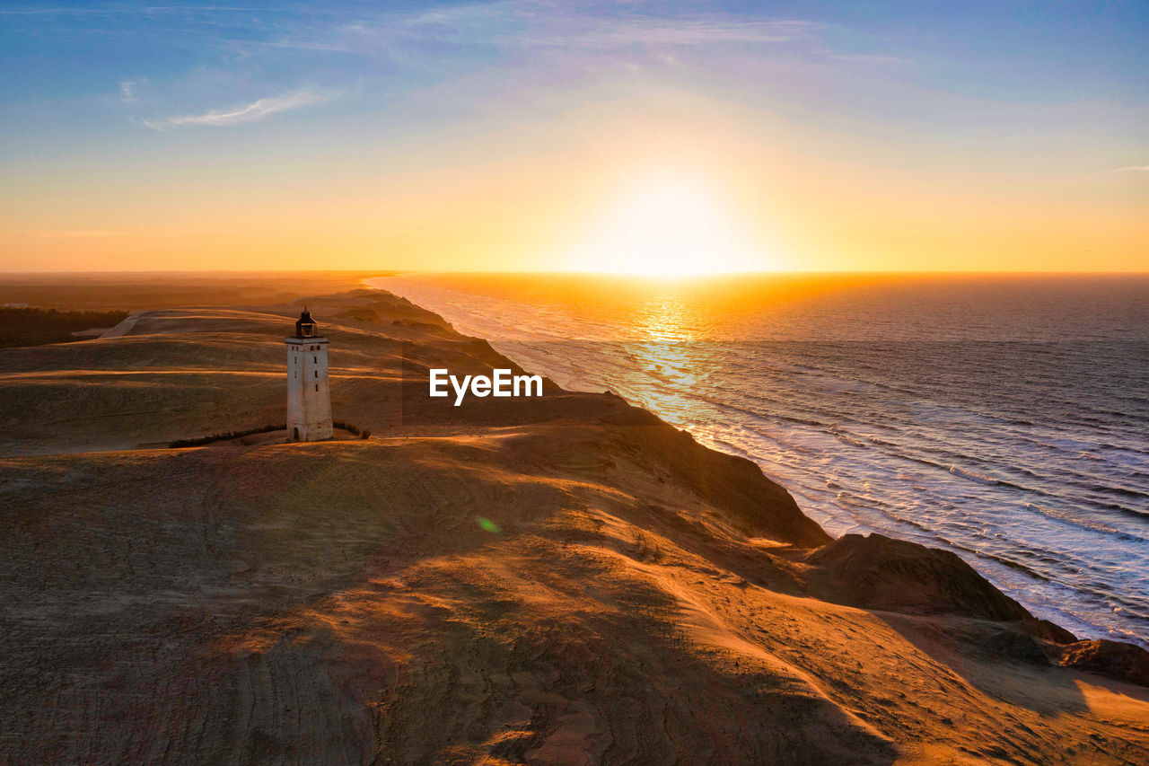 Rubjerg knude fyr lighthouse in sunset from drone