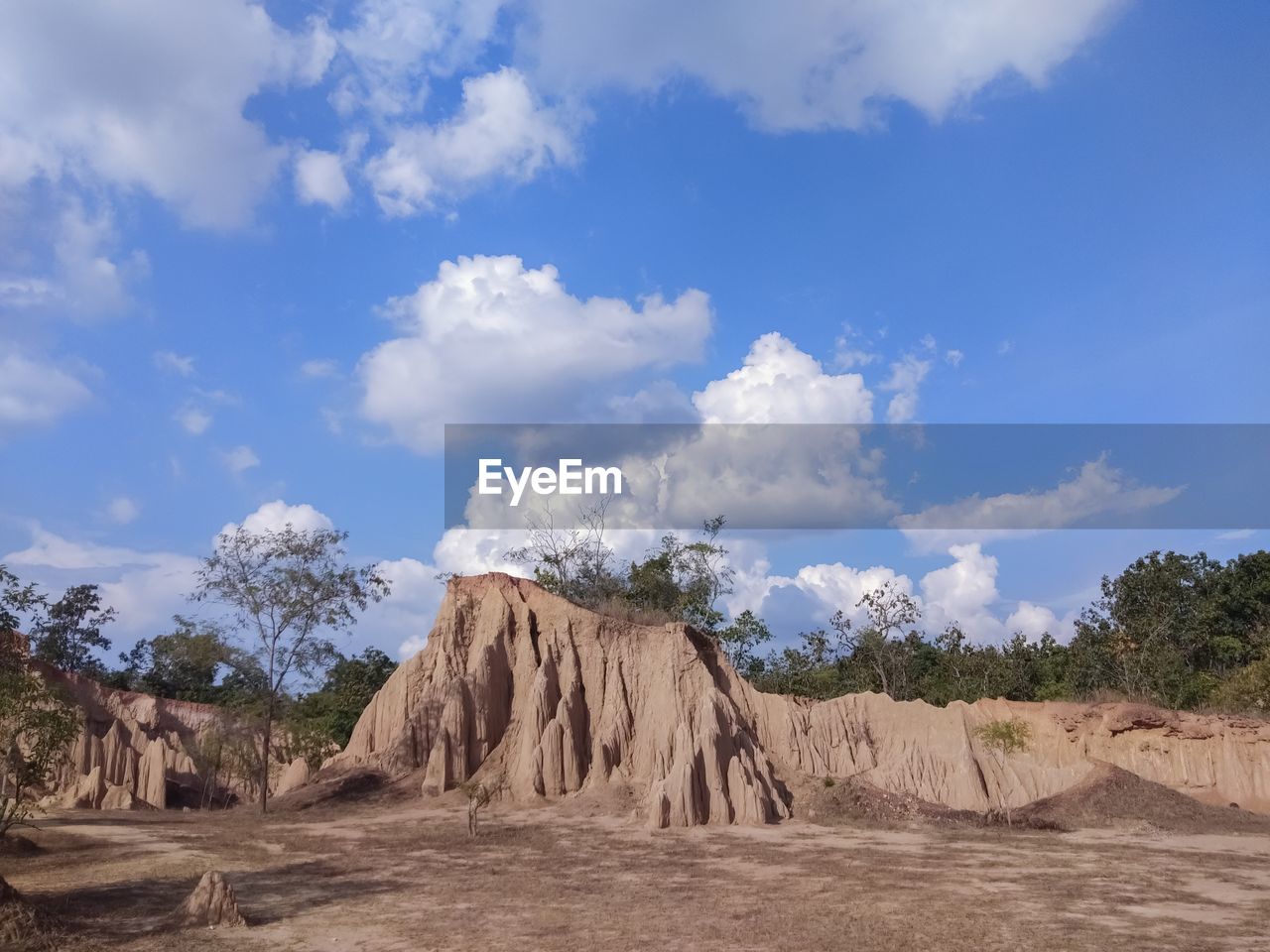 PANORAMIC VIEW OF ARID LANDSCAPE AND ROCK FORMATIONS AGAINST SKY