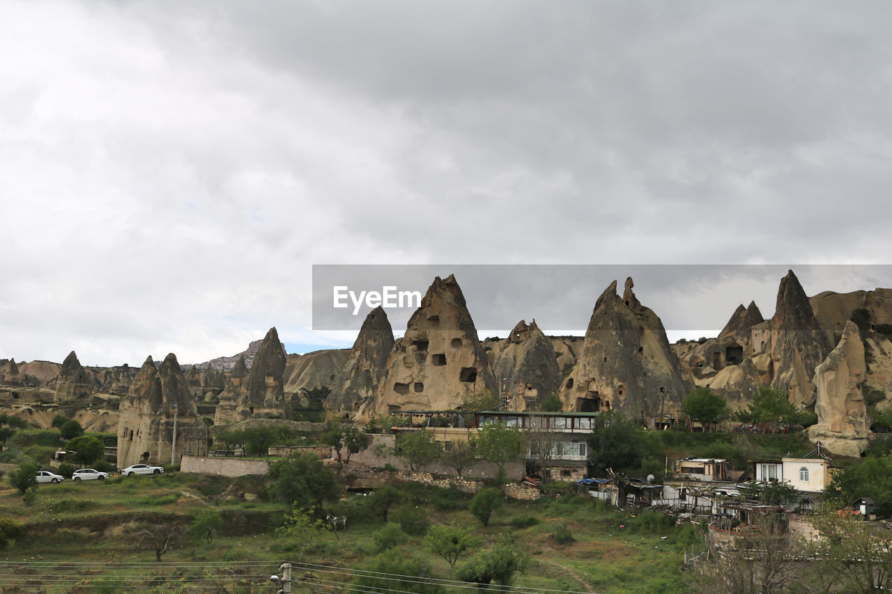 architecture, sky, cloud, travel destinations, building, nature, built structure, ruins, history, environment, landscape, travel, building exterior, the past, ancient history, land, no people, mountain, scenics - nature, tourism, outdoors, rock, landmark, overcast, religion, ancient, beauty in nature, plant, house, historic site, castle, day, non-urban scene
