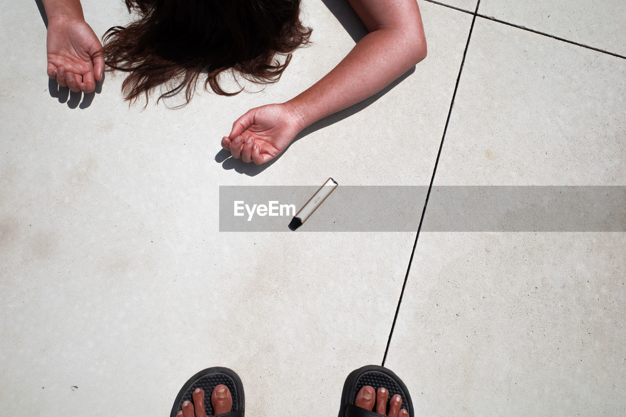 LOW SECTION OF WOMAN STANDING ON FLOOR