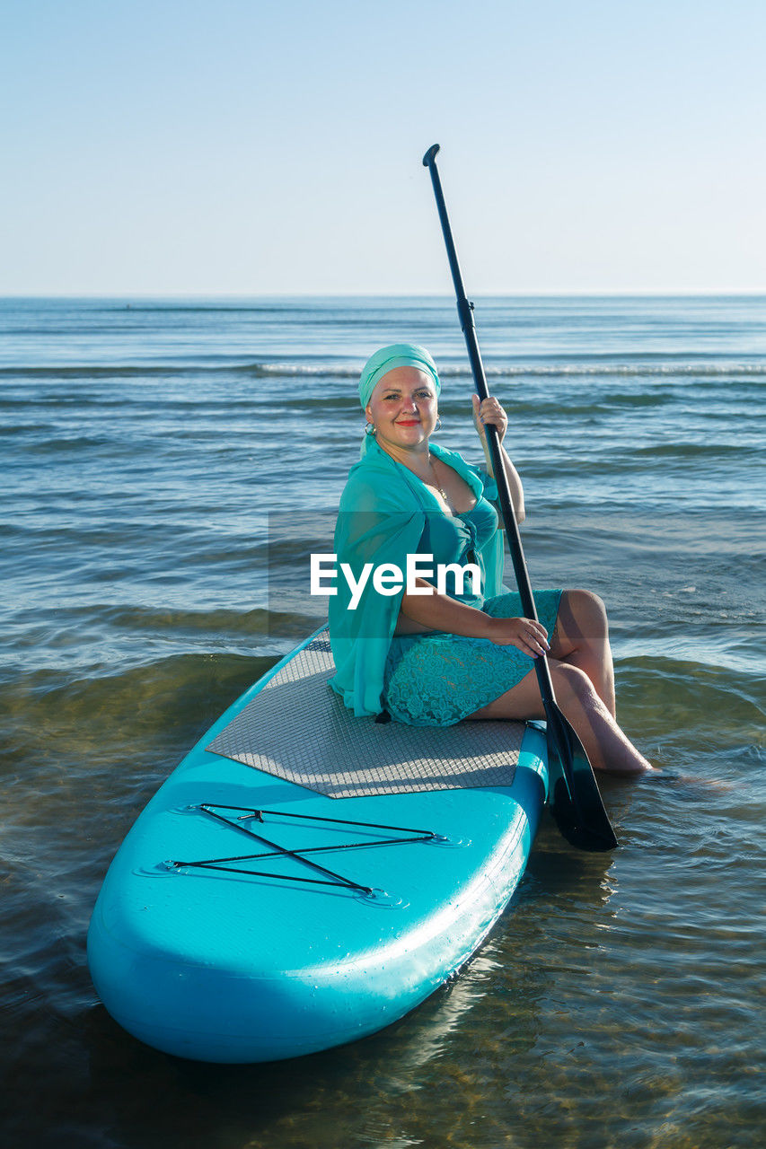 rear view of woman kayaking in sea