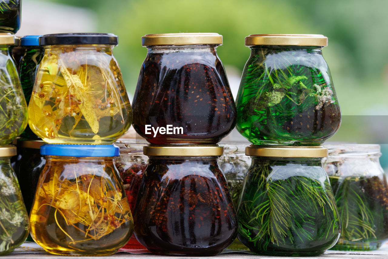 Glass jars with favoured honey - with linden, herbs and pine needles, close-up