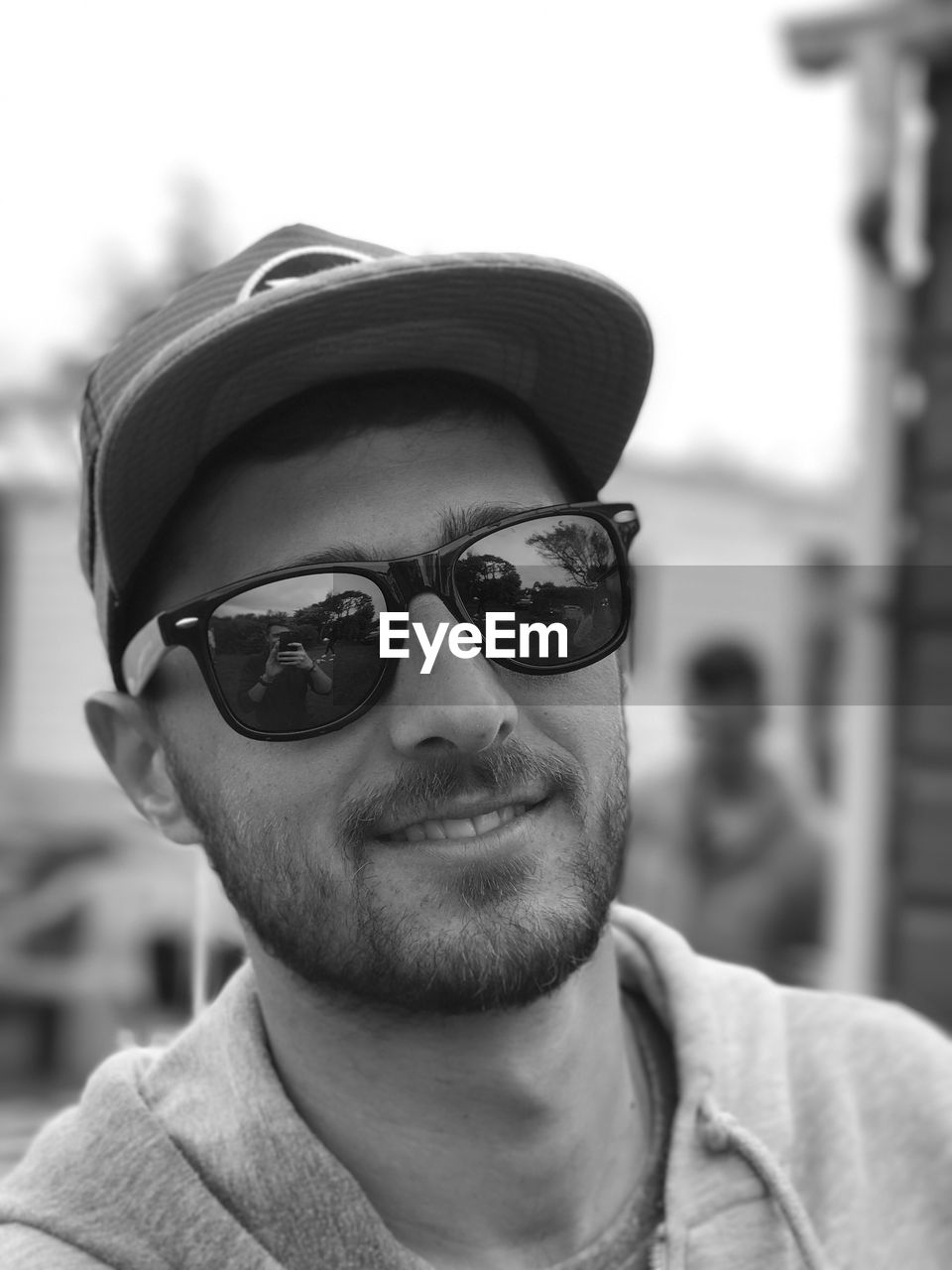 Close-up portrait of man wearing sunglasses and cap outdoors