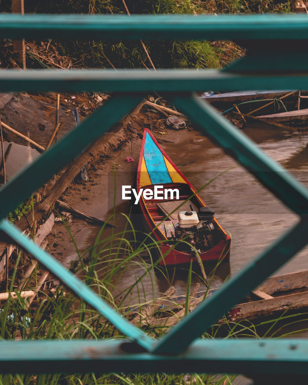 High angle view of colorful river boat through fence