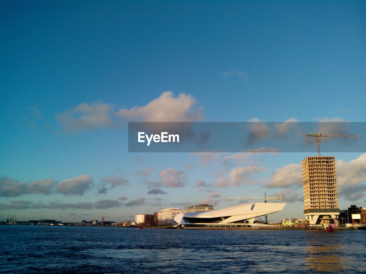 BOATS MOORED AT HARBOR AGAINST BLUE SKY