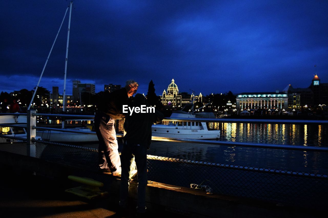 PEOPLE ON ILLUMINATED CITY AT NIGHT
