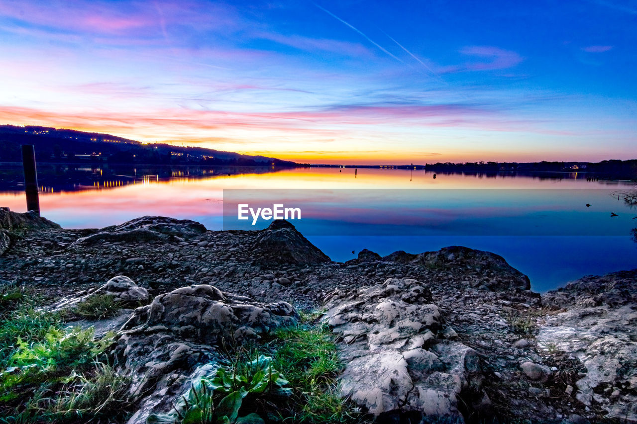 SCENIC VIEW OF LAKE AGAINST SKY AT DUSK