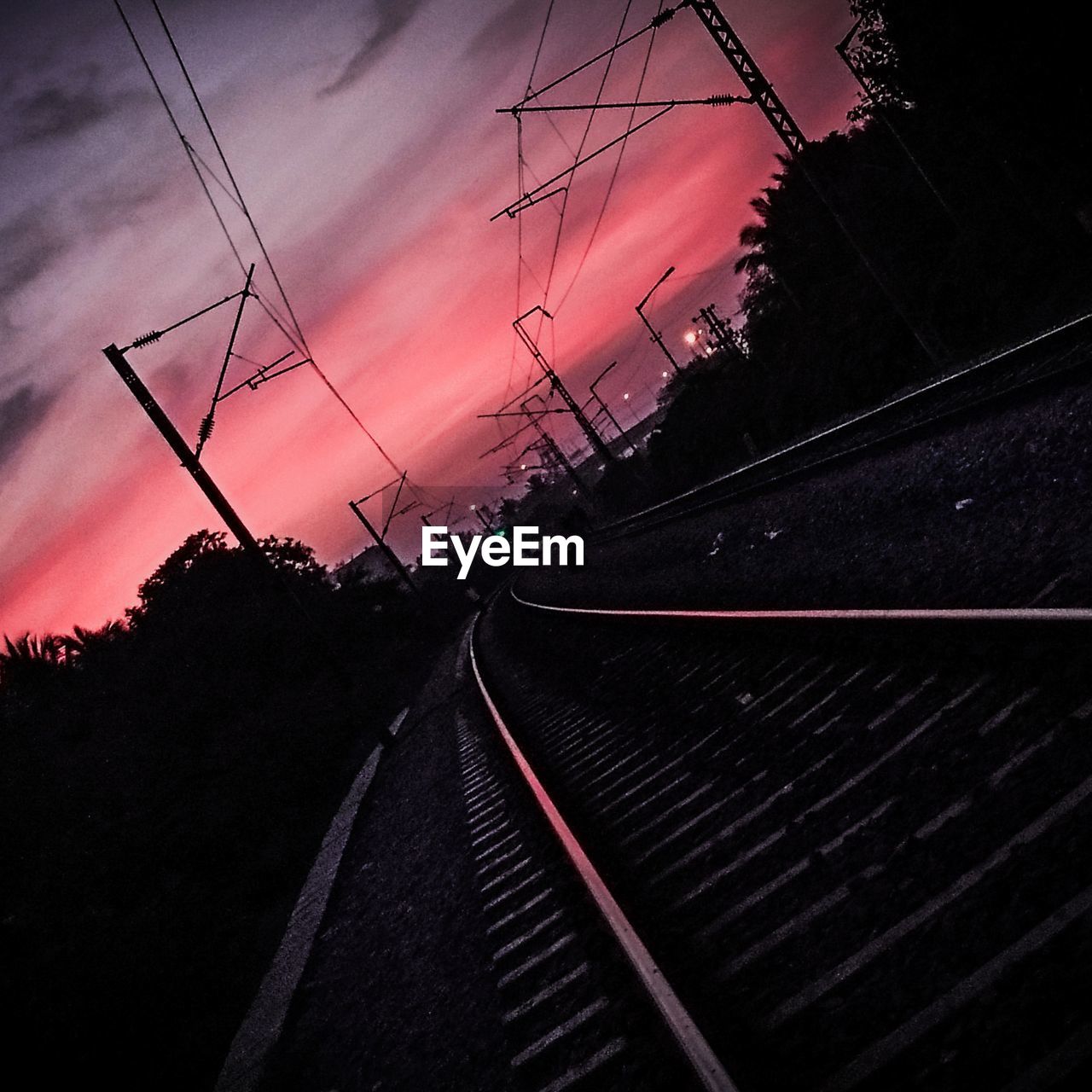 SILHOUETTE OF ELECTRICITY PYLONS AGAINST SKY