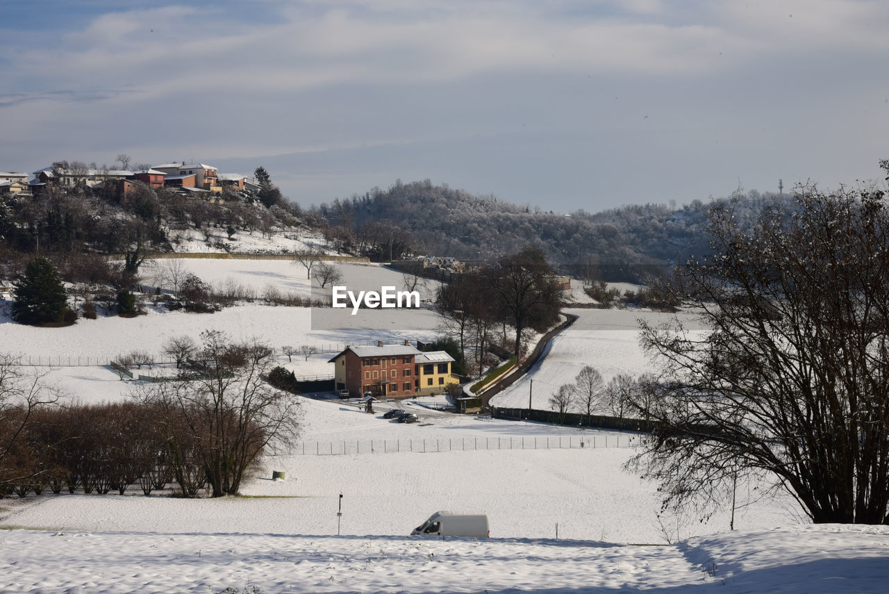 snow, winter, cold temperature, architecture, tree, nature, built structure, building exterior, building, plant, house, sky, mountain, environment, scenics - nature, landscape, beauty in nature, cloud, land, travel destinations, travel, no people, day, white, outdoors, residential district, tourism, frozen, village, holiday, mountain range