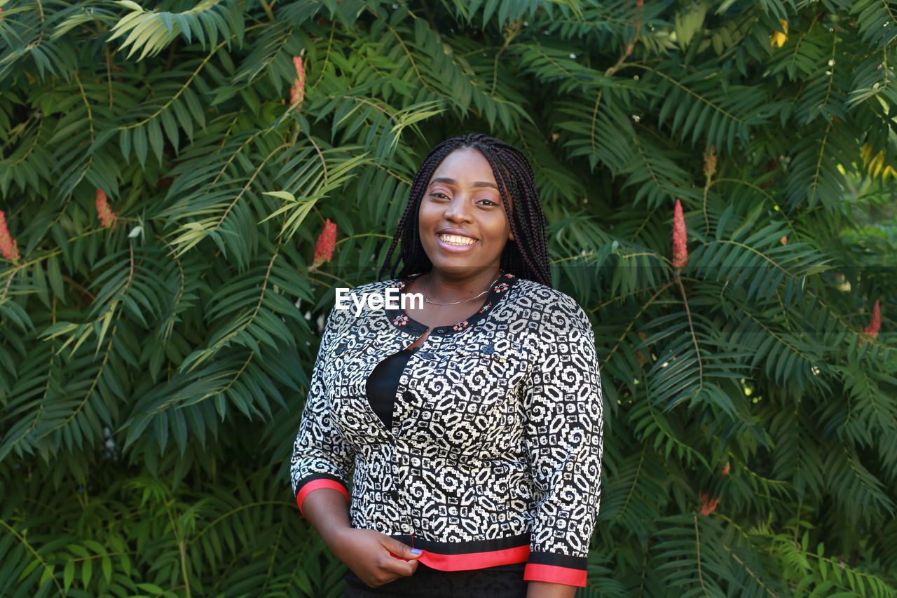 Woman with braided hair standing against plants