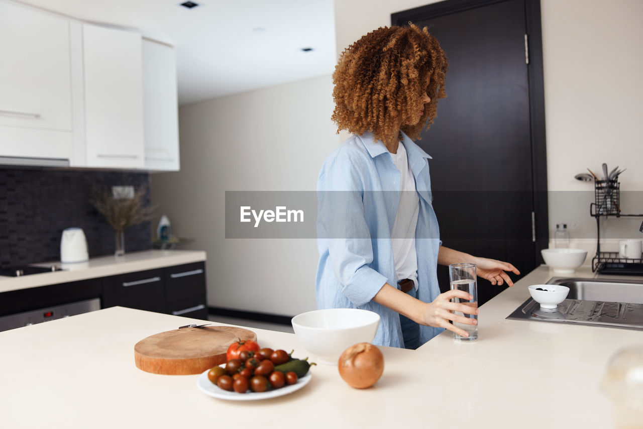 rear view of woman preparing food on table