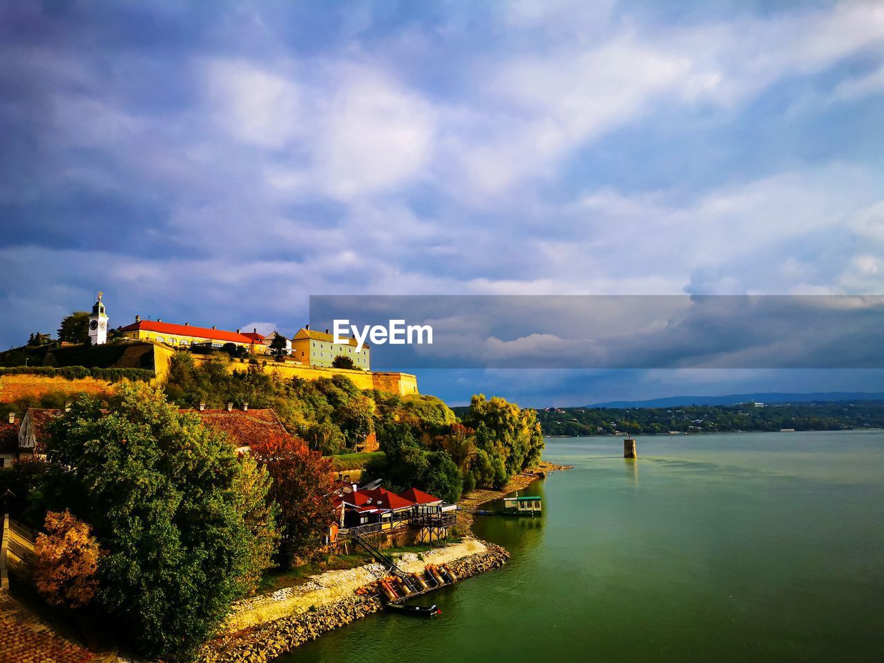 Buildings by river against sky