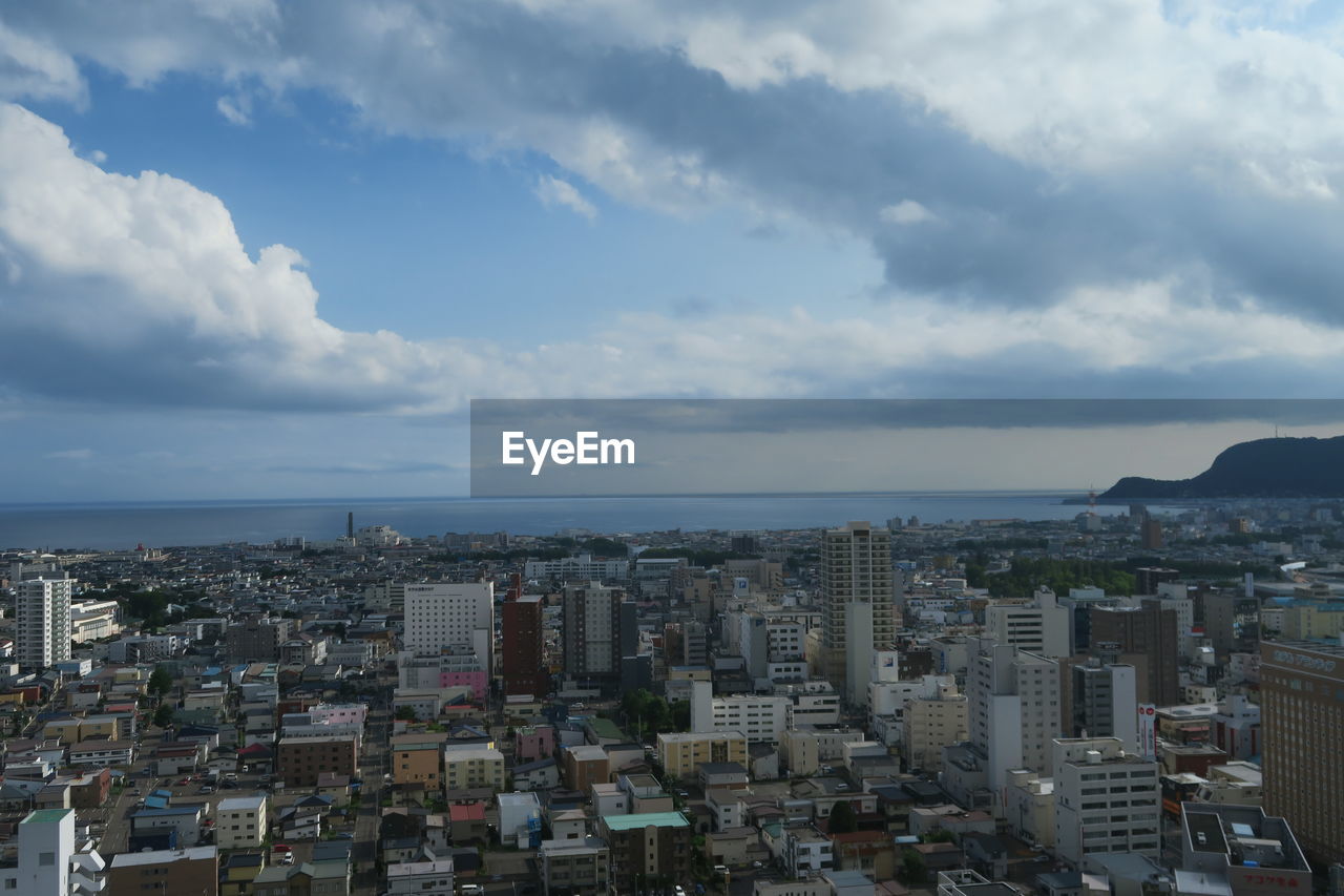 High angle view of townscape by sea against sky