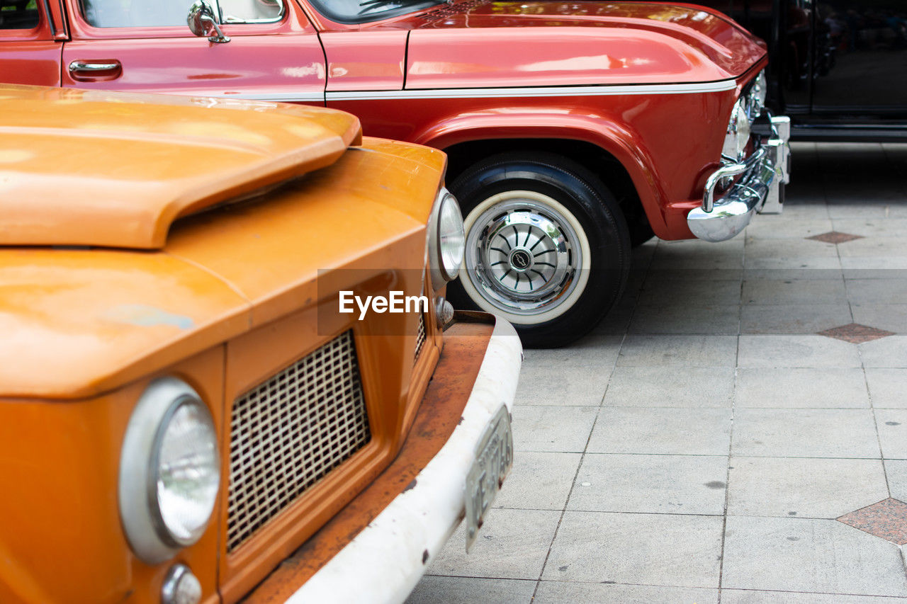 Several cars of different makes and models are seen at an exhibition of old cars