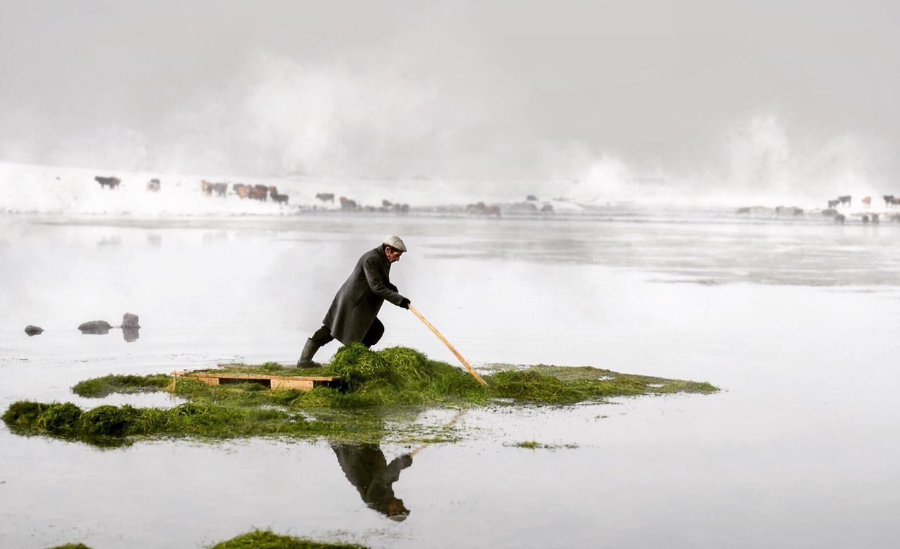 Man standing on diving platform in lake