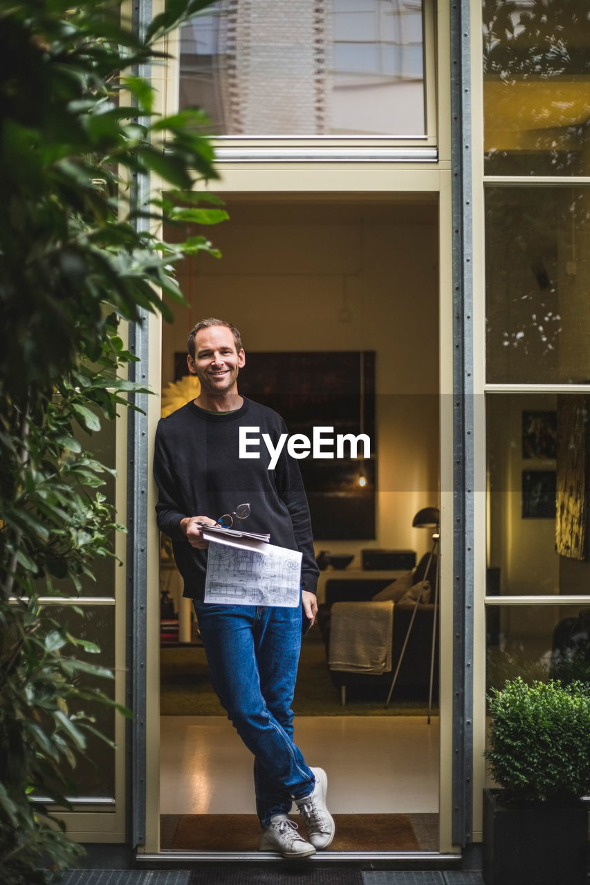 Portrait of male architect standing in house doorway