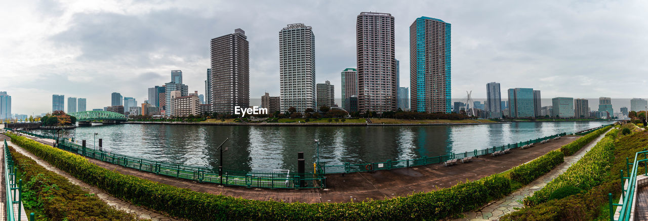 PANORAMIC VIEW OF RIVER BY BUILDINGS AGAINST SKY