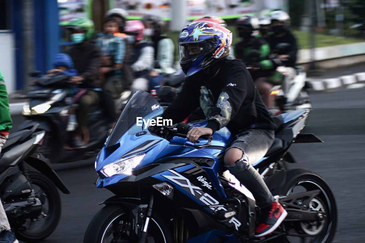 PEOPLE RIDING MOTOR SCOOTER ON ROAD