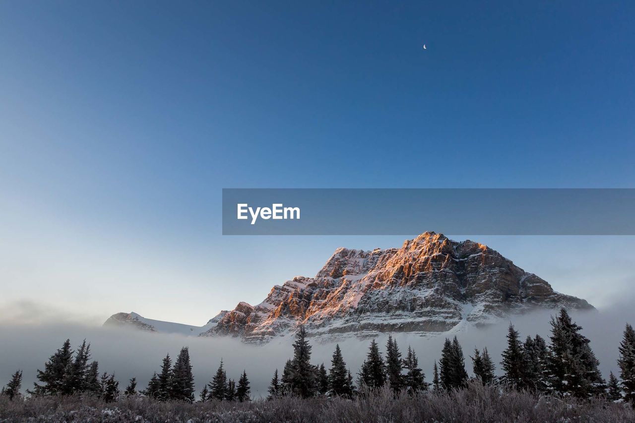 Snowcapped mountains against clear blue sky