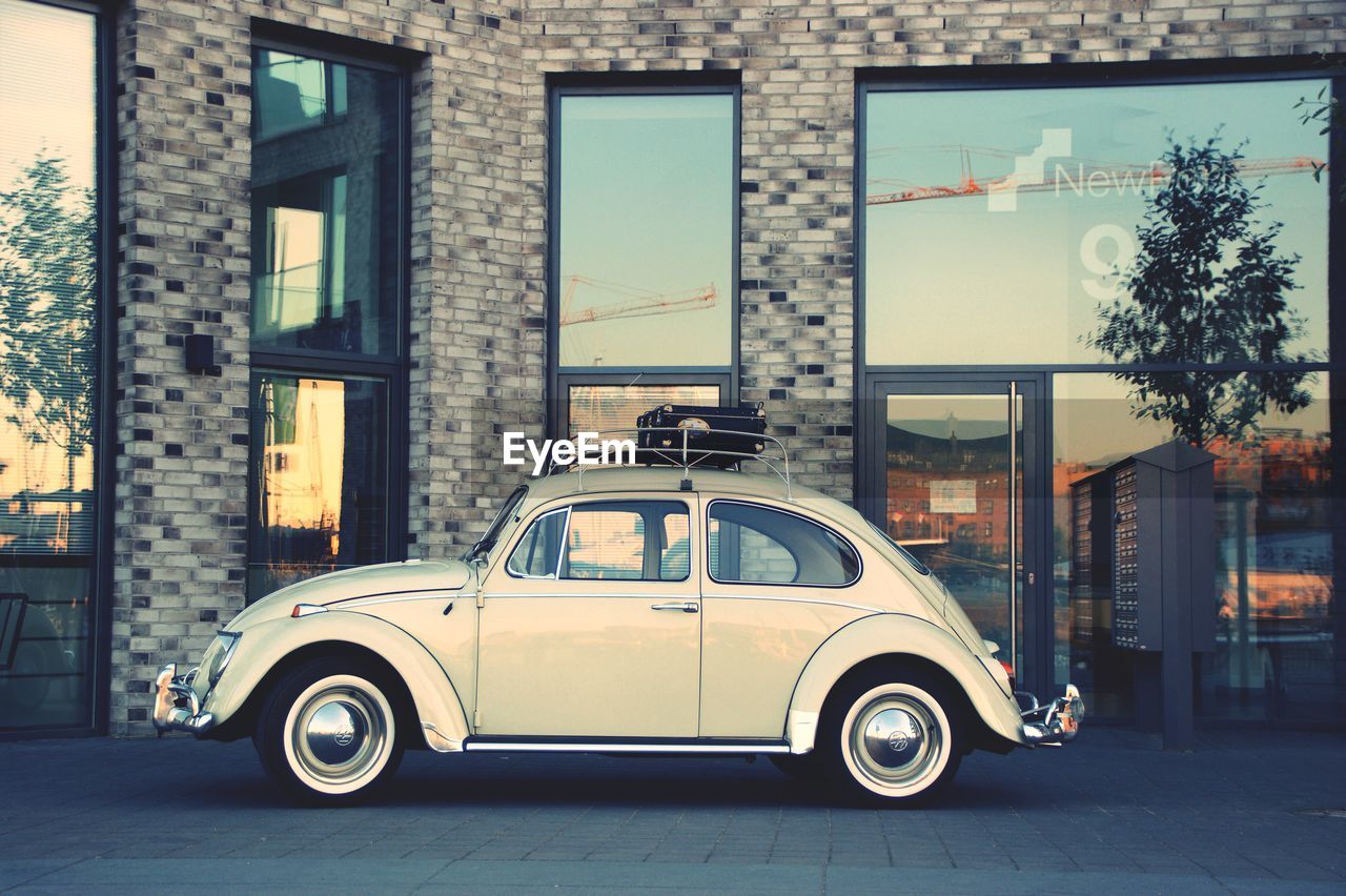 VINTAGE CAR ON STREET AGAINST BUILDING