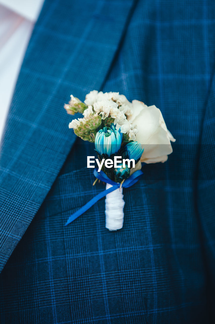 Cropped image of bridegroom wearing flowers during wedding